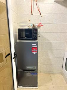 eine Mikrowelle auf einem Kühlschrank in der Unterkunft Studio Meublé de Haut Standing in Abidjan + 4 Fotos