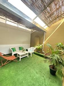 ein Wohnzimmer mit 2 Stühlen und grünem Teppich in der Unterkunft Studio Meublé de Haut Standing in Abidjan