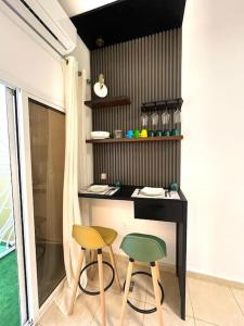 eine kleine Küche mit zwei Stühlen und einer Theke in der Unterkunft Studio Meublé de Haut Standing in Abidjan