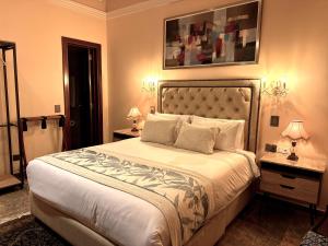 a bedroom with a large bed with two tables and two lamps at Hotel Boutique Patio Andaluz Cali Granada in Cali
