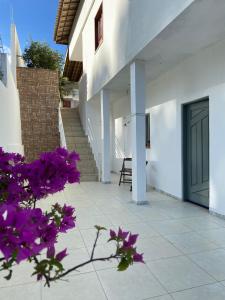 una casa con flores púrpuras delante de una puerta en Solange, en Vitória da Conquista
