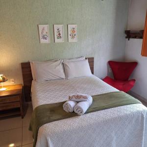 ピレノポリスにあるEco Suíte Baru Natureza Conforto e Pazのタオルが敷かれたベッドのある寝室