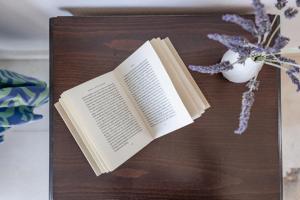 un libro sobre una mesa con un jarrón de flores en Hippocampus Apartments 2 min walk from the beach, en Moutsoúna