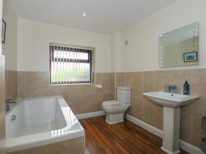 a bathroom with a tub and a toilet and a sink at Yr Hen Stabl in Caernarfon +24 photos