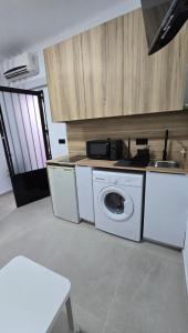 a kitchen with a washing machine and a sink at Estudio Pequeño in Conil de la Frontera