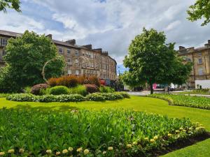a park with flowers in front of buildings at Royal Retreat Harrogate - FREE parking nearby Ultra fast Wifi in Harrogate