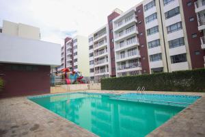 an empty swimming pool in front of some buildings at Pristine Homes Studio Apartment - Mombasa Road in Nairobi