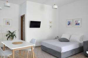 a bedroom with a bed and a table and a tv at Mary & Jo's Studios in Naxos Chora