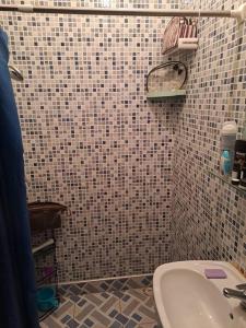 a bathroom with a sink and a tiled wall at Moonskhirat in Skhirat +4 photos