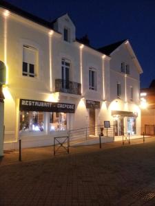 a large white building at night with lights at Hôtel de Nantes in La Bernerie-en-Retz