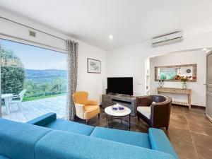a living room with a blue couch and a tv at Terrasse, Piscine privée & Charme provençal in Tourrettes-sur-Loup +44 photos