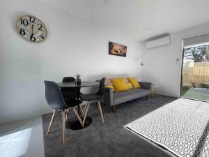 a living room with a table and a couch at Coastal Sanctuary in Christchurch +10 photos
