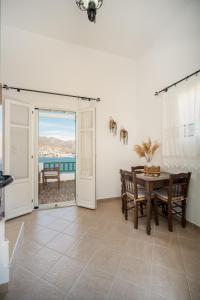 a dining room with a table and a view of the ocean at Astrio Suites in Livadi +37 photos