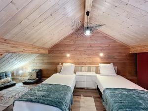two beds in a room with wooden walls at Chalet 6 pers, WiFi, parking, proche pistes - FR-1-267-297 in Villarembert