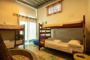 a room with three bunk beds and a window at Casa playa Puerto Luz, Alquiler vacacional in Santa Marta