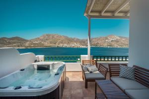 a hot tub on a balcony with a view of the ocean at Astrio Suites in Livadi