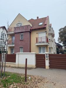 a large house with a fence in front of it at Mimi Apartman in Debrecen