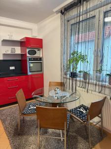 a kitchen with a glass table and a red cabinet at Mimi Apartman in Debrecen
