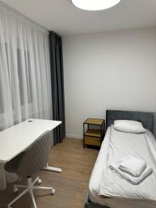 a room with a bed and a desk and a desk and a chair at Moncerat in Šiauliai