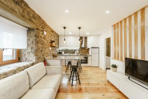 a living room with a couch and a kitchen at Casa do Castelo in Covilhã