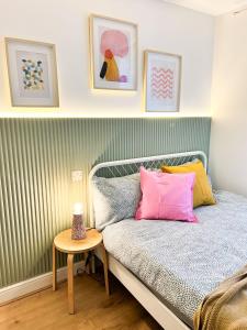 a bedroom with a bed with colorful pillows and a table at GRANBY APARTMENTS F-2 in Leicester