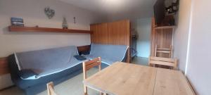a living room with a blue couch and a table at Superdevoluy Le bois d'aurouze in Superdevoluy