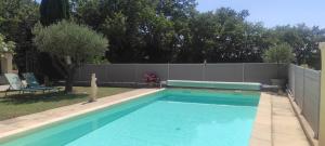 a swimming pool in a yard next to a fence at Maison au milieu des vignes in Vacqueyras +9 photos