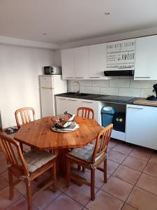 cocina con mesa de madera y 4 sillas en La petite Cabrière, en Cazouls-lès-Béziers