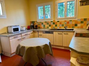 - une cuisine avec une table et un four micro-ondes dans l'établissement FASLAM 1455, aux Issambres
