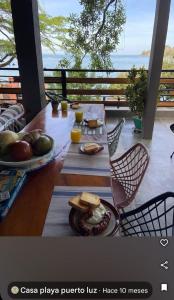 a table with food and orange juice on a balcony at Casa playa Puerto Luz, Alquiler vacacional in Santa Marta