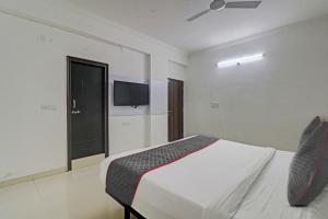 une chambre avec un lit et une télévision à écran plat dans l'établissement Super TOWNHOUSE JAHNAVI GROUP BESIDES NEXUS MALL, à Hyderabad