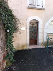 un edificio con una puerta marrón con un arco en La petite Cabrière, en Cazouls-lès-Béziers