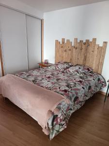 Un dormitorio con una cama con cabecero de madera. en La petite Cabrière, en Cazouls-lès-Béziers