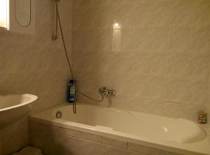 a bathroom with a bath tub with a shower at DebreCenter Apartman in Debrecen +7 photos