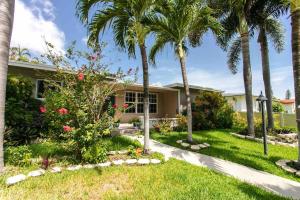 a house with palm trees in the yard at MIAMI Art Villa Heated Saltwater Pool with SPA EV in Dania Beach