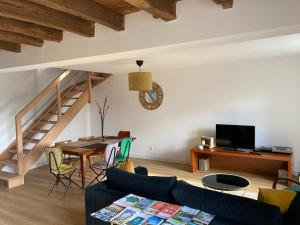 a living room with a couch and a table at Les palis de Sert in La Chapelle-de-Brain