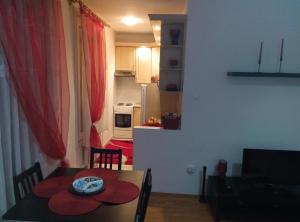 una cocina y comedor con mesa y una habitación con cocina en DebreCenter Apartman, en Debrecen