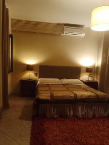 a bedroom with a bed and two lamps and a window at B&B Kazakova in Domusnovas