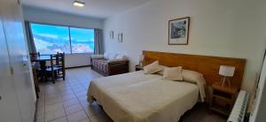 ein Schlafzimmer mit einem Bett, einem Stuhl und einem Fenster in der Unterkunft El encanto del lago in San Carlos de Bariloche