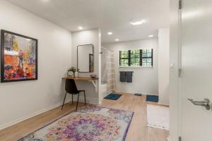 a bathroom with a table and a mirror and a chair at Turkey Mountian Trailside By Tulsa Getaways in Tulsa +25 photos