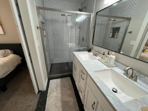 a bathroom with two sinks and a shower with a mirror at Rt 66 Fairgrounds Retreat By Tulsa Getaways in Tulsa +9 photos