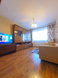 un soggiorno con un divano e una TV di 2-х комнатная квартира в центре a Karagandy