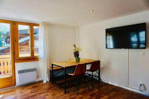 Una habitación con una mesa y un televisor en una pared. en Central Local Flat, en Zermatt 27 fotos más
