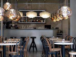 een restaurant met tafels, stoelen en verlichting bij Hipsters Hotel in Thessaloniki