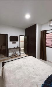 Un dormitorio con una cama grande y un televisor de pantalla plana. en Casa de huéspedes SKY BLUE, en Barranquilla