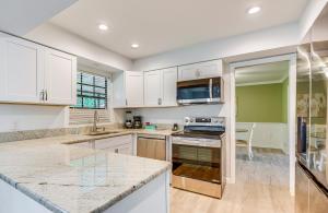 a kitchen with white cabinets and a counter top at Less Than 1 Mi to Restaurants and CCF Ocala Home with Yard! in Ocala