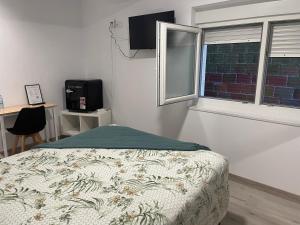 a bedroom with a bed and a window and a television at Pension Casa Pedro in Fisterra