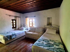 a living room with two beds and a couch at Stone house in Faralya in Fethiye