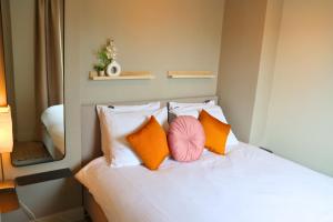 ein Schlafzimmer mit einem Bett mit Kissen und einem Spiegel in der Unterkunft Casa Galia Apartments in Nijmegen + 1 Foto
