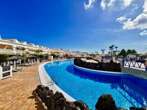 una piscina en un complejo con agua azul en Sweet Home Apartman, en San Miguel de Abona